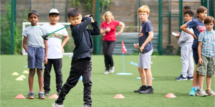 England Golf Partners with Mind to Support Mental Wellbeing Young golfers practicing their skills while receiving guidance from a coach.