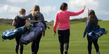 Welsh golfers pictured on the fairway carrying their golf clubs.