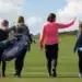 Join Wales Golf Day on June 7th & Help Break a National Record Welsh golfers pictured on the fairway carrying their golf clubs.