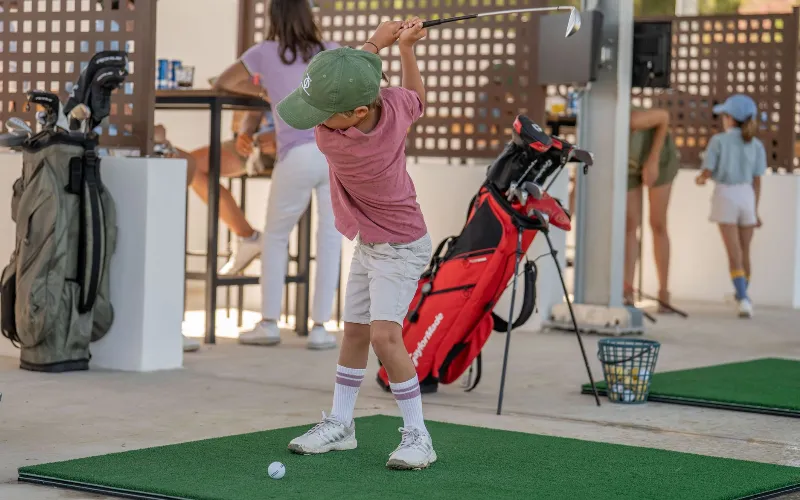 World-Class Golf Academy Opens at The Alto Club a boy swinging a golf club
