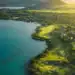 Anahita Golf & Spa Resort Welcomes New Management Partner A golf course with a body of water and a hill in the background.