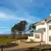 Dunluce Lodge: Five-Star Luxury on the Edge of Royal Portrush A large white house with a golf course and trees.