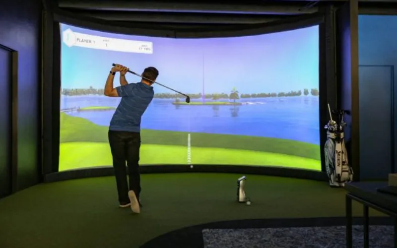 88% Say Golf Simulators Boost Game Performance a man playing golf in a room