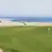 Golf de Moliets Joins Resonance Golf Collection A golf course with a flag on the beach.