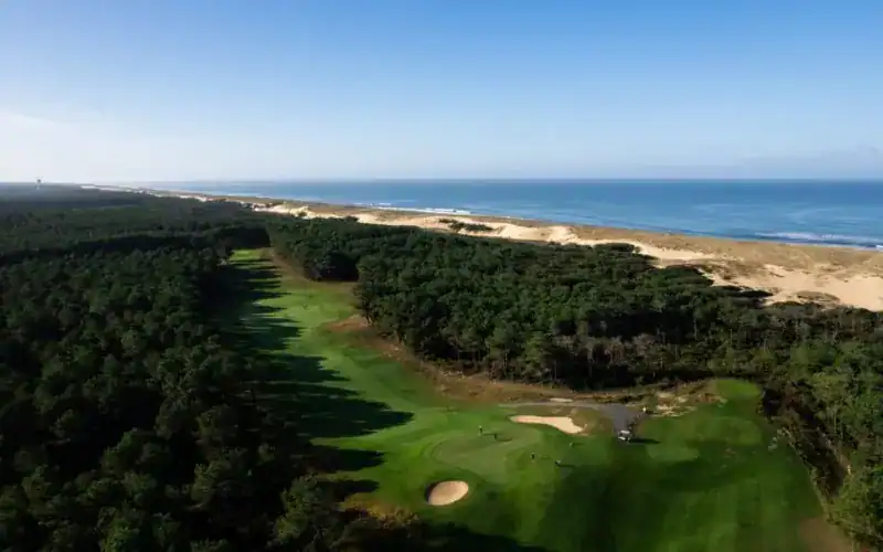 Golf de Moliets Joins Resonance Golf Collection A golf course with sand bunkers and trees on the beach.