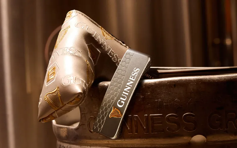 Bettinardi Golf & Guinness Launch Exclusive Collaboration A silver and gold putter with a Guinness logo on it.