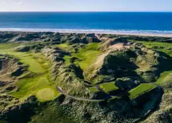 Discover Why Northern Ireland is a Golfer’s Paradise A golf course with the sea and beach in the background.