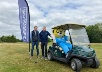 a man standing next to a person in a golf cart