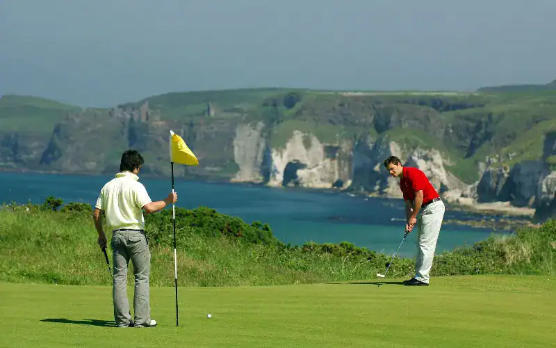 Discover Why Northern Ireland is a Golfer’s Paradise A group of men playing golf on Royal Portrush.