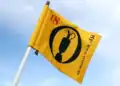 Spidercam Revolutionises Golf Coverage at The 153rd Open a yellow flag with a black and red design on it