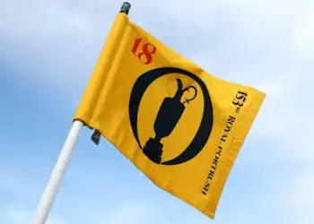 The 153rd Open at Royal Portrush Sets New Records a yellow flag with a black and red design on it