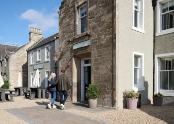 The Leddie a Standout Stay on Scotland’s Golf Coast a man and woman walking in front of a building