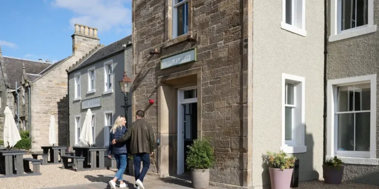 The Leddie a Standout Stay on Scotland’s Golf Coast a man and woman walking in front of a building