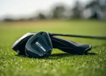 Titleist GT1 3TOUR fairway wood resting on fairway grass with headcover in background.