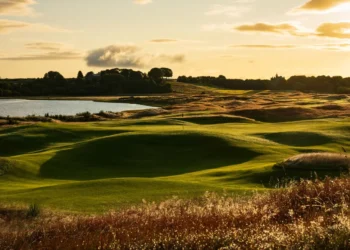 Tom Doak’s Old Petty Course Set for Summer Debut at Cabot Highlands a golf course with a lake and trees