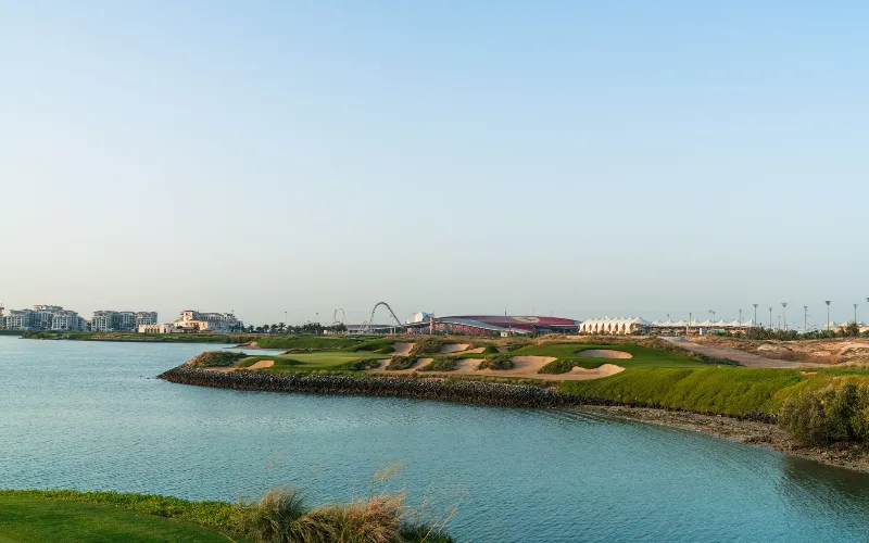 Viya Golf GEO Certification for Yas Links and Yas Acres A golf course with a body of water and a building.