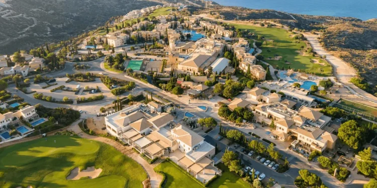 Aphrodite Hills Launches Major Investment Plan a aerial view of a town with a pool and a body of water