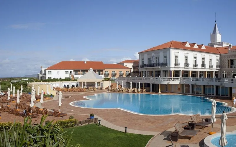 Marriott Praia D’El Rey Golf & Beach Resort a swimming pool with a building in the background