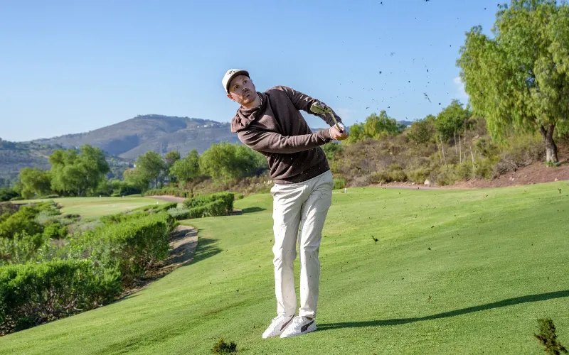 PUMA GOLF Unveils x ARNOLD PALMER Collection for 2025 a man swinging a golf club
