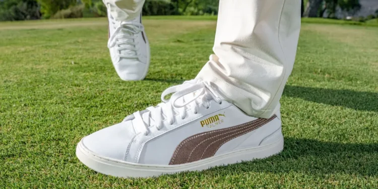 PUMA GOLF Unveils x ARNOLD PALMER Collection for 2025 a person's feet in white shoes on grass