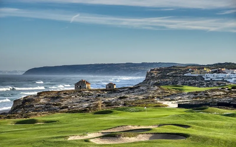 Marriott Praia D’El Rey Golf & Beach Resort a golf course with a beach and a house