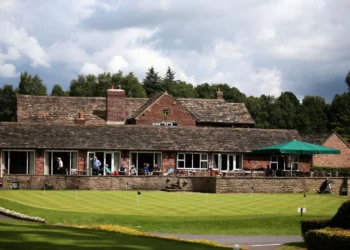 Prestbury’s Joan Crouch Wins Wild Cup at 90 Years Old a building with people sitting on the porch