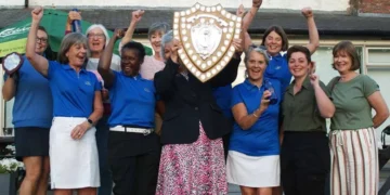 a group of women holding a shield