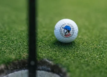 Srixon Celebrates U.S. Captaincy with Keegan Bradley Signature Series Golf ball near hole on green.