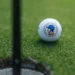 Srixon Celebrates U.S. Captaincy with Keegan Bradley Signature Series Golf ball near hole on green.