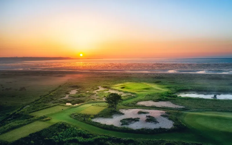 Sunset over tranquil golf course landscape